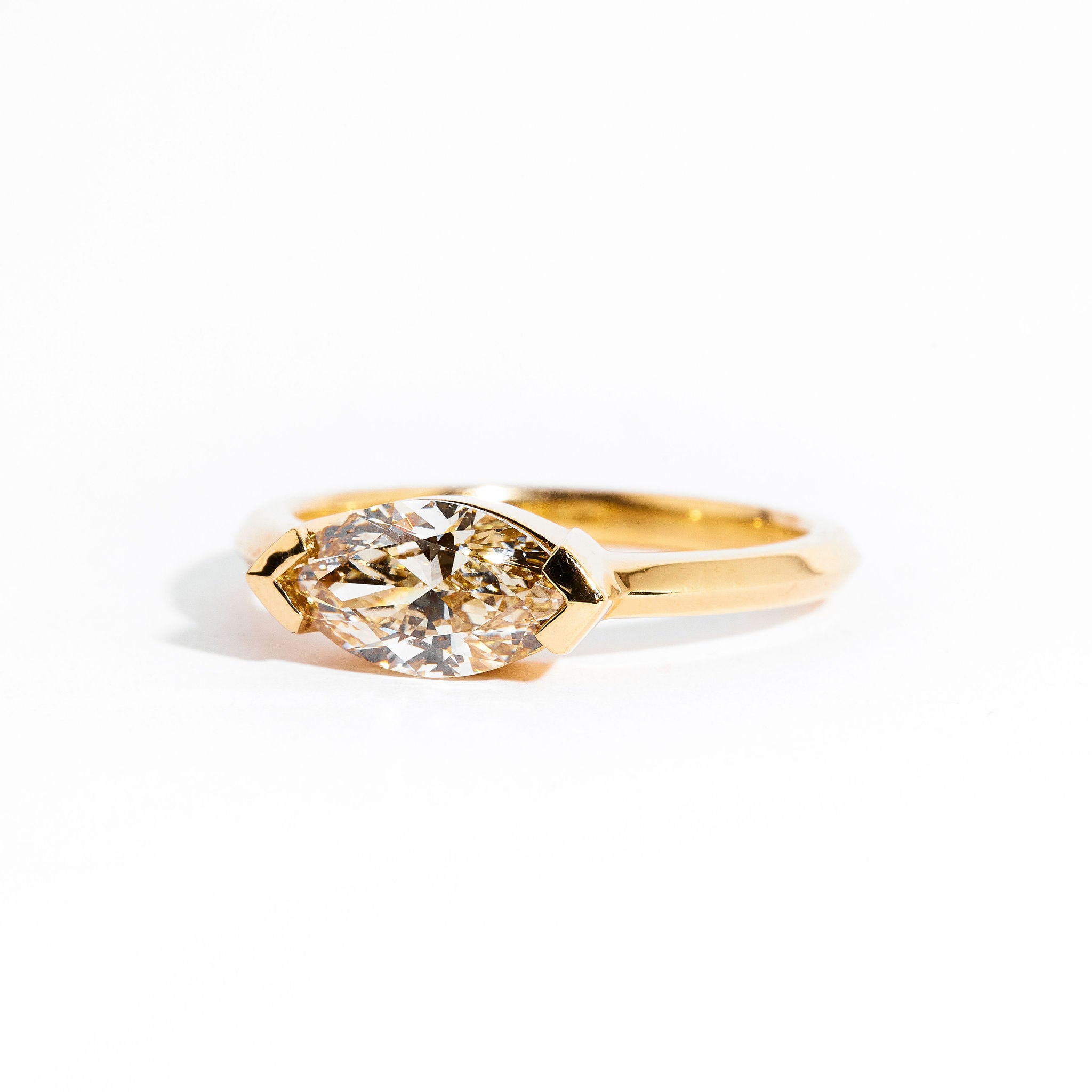 Hand crafted 18 carat yellow gold solitaire ring with marquise champagne diamond.